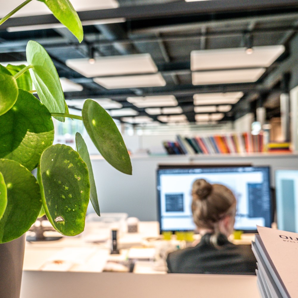 Achterkant van een Crius-medewerker aan haar bureau